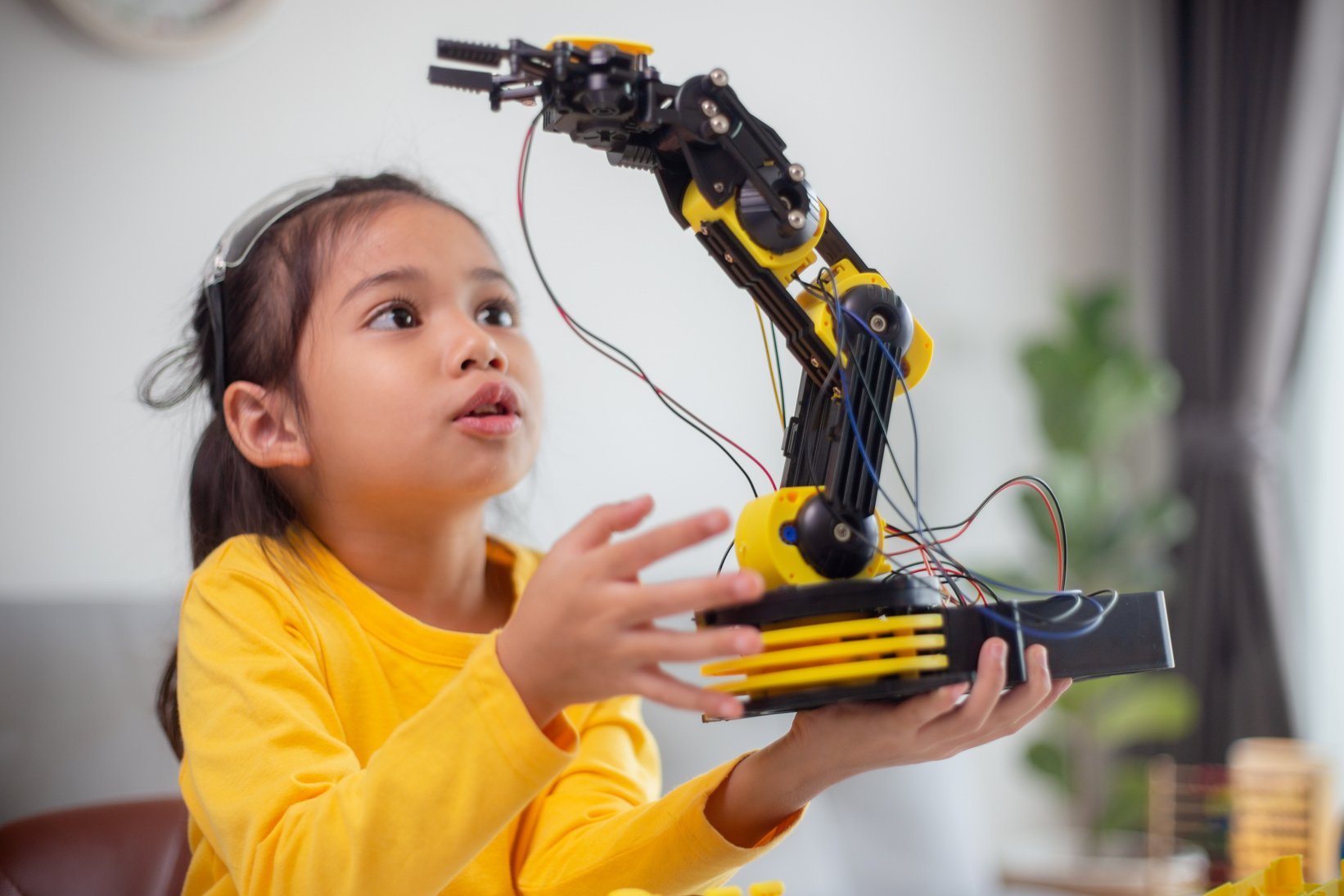 STEM education concept. Asian students learn at home by coding robot arms in STEM, mathematics engineering science technology computer code in robotics for kids' concepts.